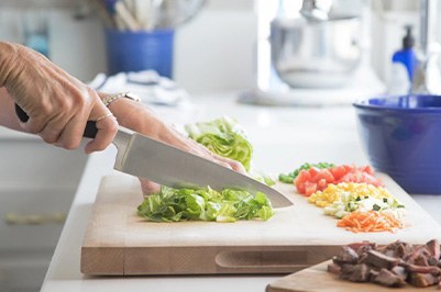 Close-up of woman’s hands chopping lettuce