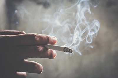 Close up of a hand holding a cigarette 